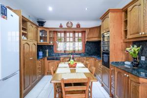 Una cocina con gabinetes de madera y una mesa de madera. en Gżira Well-Equipped 4BR Flat in Peaceful - GV, en Il-Gżira