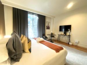 ein Hotelzimmer mit einem Bett mit einem großen Fenster in der Unterkunft Charming Studio Apartment in Auckland Central in Auckland