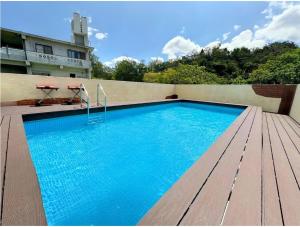 uma piscina na lateral de um prédio em グランディオーソ沖縄プールヴィラ恩納6 em Onna