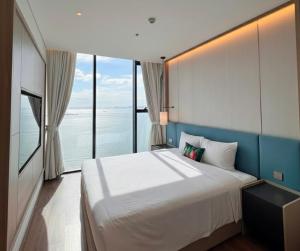 a bedroom with a large bed and large windows at A La Carte Ha Long Oceanview Fireworksview Panoramic 2BR2WC suite with balcony in Ha Long +73 photos