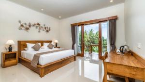 a bedroom with a bed and a balcony at Lavana Ubud in Ubud