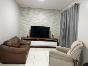 un soggiorno con un divano e una televisione di Lar da Dora a Parauapebas