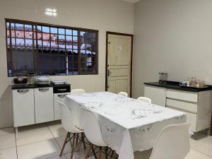 una cucina con un tavolo bianco e sedie bianche di Lar da Dora a Parauapebas