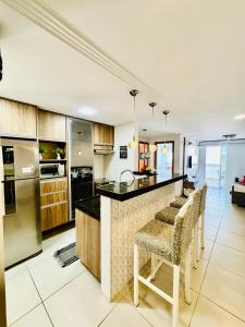 a kitchen with a bar with stools and a counter top at Resort Praia Grande in Arraial do Cabo
