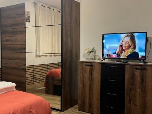 a bedroom with a television on a dresser with a bed at Relax Home Holiday in Panicale