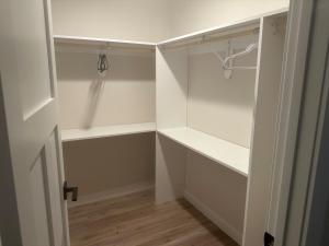 a walk in closet with white walls and wooden floors at Luxurious Brand New Entire 3br and 2bath in Williston +40 photos