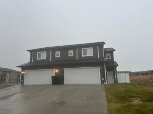 a house with two garage doors on a driveway at Luxurious Brand New Entire 3br and 2bath in Williston