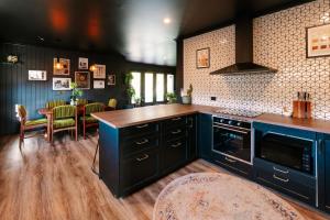 Black Diamond - Pet Friendly, Magnesium Spa في برايت: مطبخ مع دواليب زرقاء وطاولة وكراسي