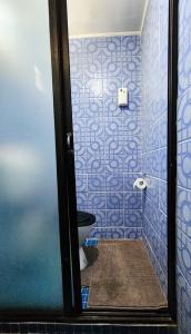 Baño de azulejos azules con aseo en sunny's homestay, en Sigatoka 4 fotos más