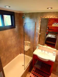 a bathroom with a tub and a sink and a mirror at Pachanavira Cabañas & Suites in Nono