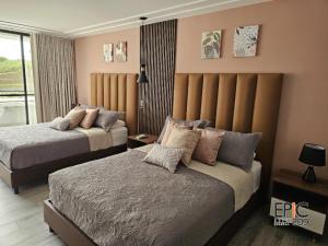 a hotel room with two beds and a window at Epic Suite 209 Deluxe Aeropuerto in Cuba