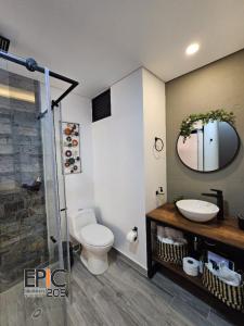 a bathroom with a toilet and a sink and a mirror at Epic Suite 209 Deluxe Aeropuerto in Cuba