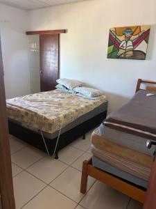 UruçucaCasa de Praia Serra Grande X Itacaré的一间卧室，墙上有两张床和一幅画