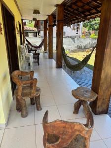 UruçucaCasa de Praia Serra Grande X Itacaré的带木制家具和吊床的门廊