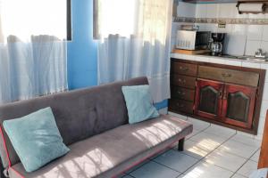 a couch with two blue pillows sitting in a kitchen at Apto casco histórico Acropolis in Comayagua
