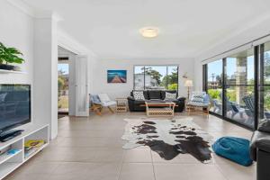 文森提亚Summer-Salt by Experience Jervis Bay的客厅里有一张沙发和一台电视