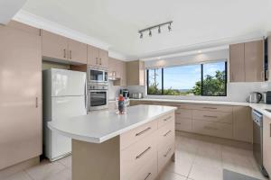 文森提亚Summer-Salt by Experience Jervis Bay的一间厨房,配有白色家电和大窗户