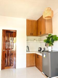 a kitchen with wooden cabinets and a refrigerator at Zand Pointe Suites in General Luna