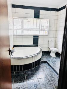 a bathroom with a tub and a toilet at BTV Villa in Hazyview +6 photos