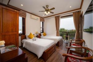 a hotel room with two beds and a balcony at Ony Retreat Villas in Hoi An