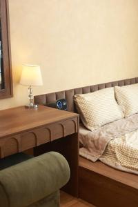 une chambre avec un lit et une table avec une lampe dans l'établissement Gờ Homestay - Sentosa Sky Park - Khép kín, à An Khê