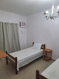 a hospital room with a bed and a chandelier at RR 2 Pousada e Restaurante in Manaus