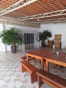 a patio with wooden tables and chairs and palm trees at RR 2 Pousada e Restaurante in Manaus