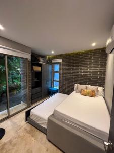 a bedroom with two beds and a brick wall at Cabaña privada con piscina y jacuzzi junto al mar in Santa Veronica