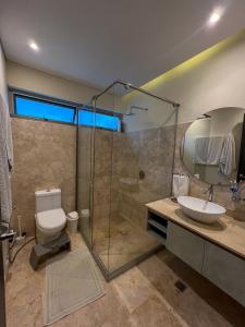 a bathroom with a toilet and a sink and a shower at Cabaña privada con piscina y jacuzzi junto al mar in Santa Veronica