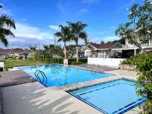 a swimming pool in a yard with houses at Villa Amore in Dauis