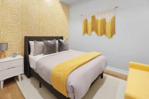 une chambre avec un lit avec une couverture jaune dessus dans l'établissement Stylish 3BR CN Tower Views & Patio Mini Putt, à Toronto