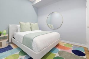 une chambre avec un lit et un miroir dans l'établissement Stylish 3BR CN Tower Views & Patio Mini Putt, à Toronto