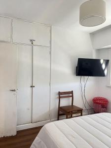 Un dormitorio con una cama, un televisor y una silla. en La gracie, en San Bernardo 17 fotos más