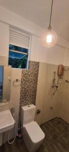 a bathroom with a white toilet and a sink at mountain retreat in Kandy
