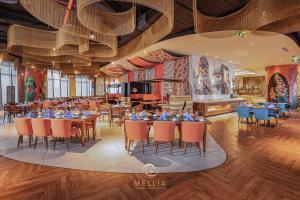 un restaurant avec des tables et des chaises dans une salle dans l'établissement MELLIA OCEANUS NHA TRANG BAY Five-Star Suites, à Nha Trang 92 autres photos