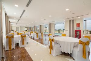 ein Bankettsaal mit weißen Tischen und gelben Schleifen in der Unterkunft TAO DAN hotel in Ho-Chi-Minh-Stadt + 70 Fotos