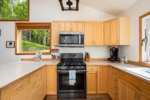 una cucina con fornelli e microonde di Cozy Lakefront Retreat a Wasilla