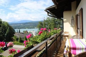 a balcony with flowers and a view of a lake at Dreimäderlhaus in Velden am Wörthersee