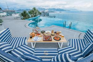 Una mesa con comida al lado de una piscina. en MELLIA OCEANUS NHA TRANG BAY Five-Star Suites, en Nha Trang