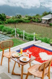 - une table avec des assiettes de nourriture et des boissons sur la terrasse dans l'établissement Nadine Villa Kintamani with Natural Hot Spring, à Kubupenlokan