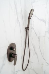 une pomme de douche est suspendue sur un mur dans l'établissement Nadine Villa Kintamani with Natural Hot Spring, à Kubupenlokan 47 autres photos