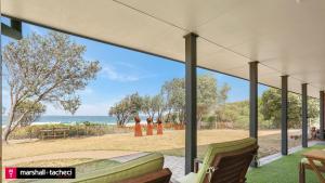 a view of the beach from the porch of a house at Art House - 4 Bedroom in Barragga Bay
