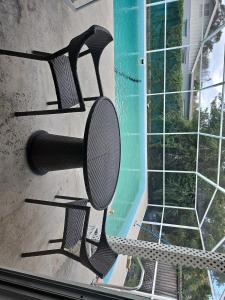 新里奇港Newly Renovated Vacation home with Spacious Pool的游泳池前的一把空椅子