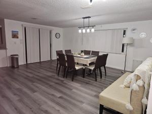 新里奇港Newly Renovated Vacation home with Spacious Pool的一间带桌椅和沙发的用餐室