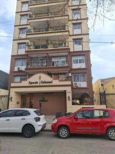 Dos coches aparcados delante de un edificio en Excellent Monoambiente, en Santos Lugares