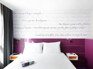 Dormitorio con cama con escrito en la pared en ibis Styles Montpellier Centre Comedie, en Montpellier