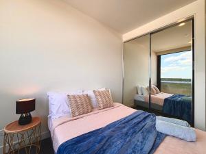 北克莱顿M-City Monash Spacious Skyline Escape & Hospital的带床和镜子的卧室