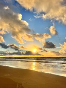 a sunset on a beach with the ocean at Surf e Café in Cabo de Santo Agostinho