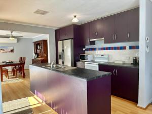 a kitchen with purple cabinets and a counter top at Among the Gums in Clare