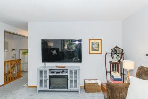 Una sala de estar con televisión y chimenea. en Bayview Bed and Breakfast, en Mill Bay